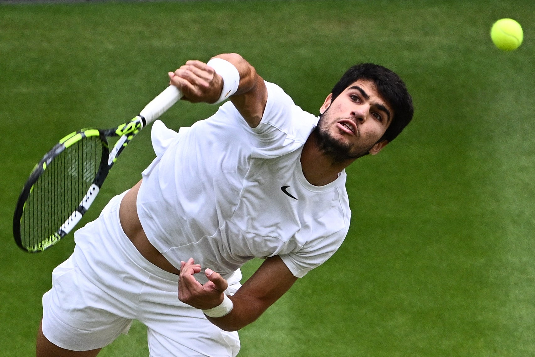 El español Carlos Alcaraz sirve contra el serbio Novak Djokovic durante la final del Campeonato de Wimbledon 2023