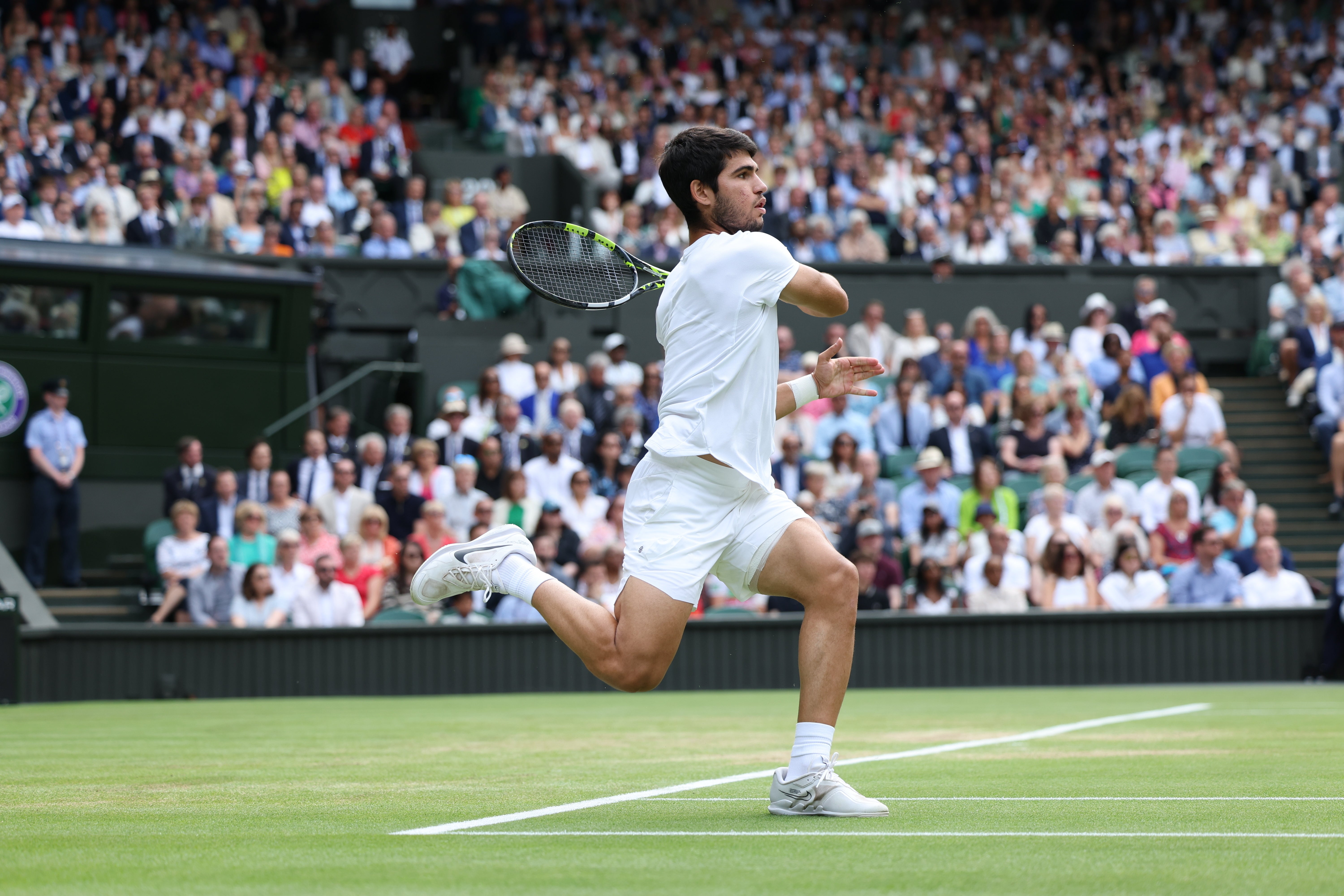 El español Carlos Alcaraz sirve contra el serbio Novak Djokovic durante su último partido de tenis individual masculino el último día del Campeonato de Wimbledon 2023