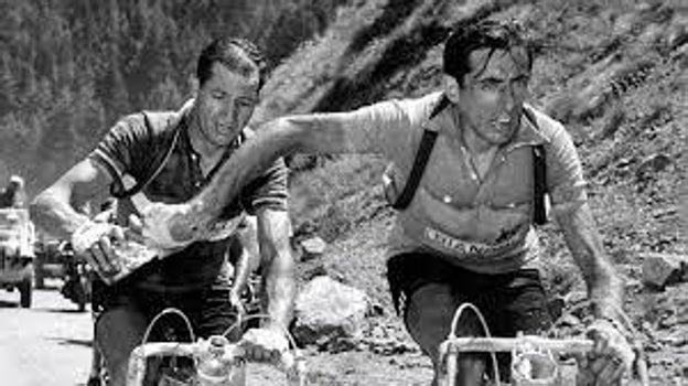 Fausto Coppi y Gino Bartali se pasan un bidón de agua en pleno ascenso al Telegraphe en el Tour de 1952