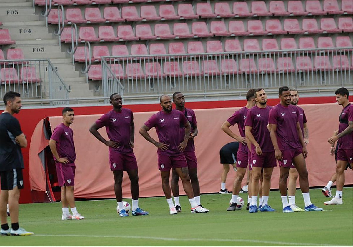 Varios jugadores del Sevilla FC escuchan instrucciones durante un entrenamiento previo al partido contra el Real Madrid