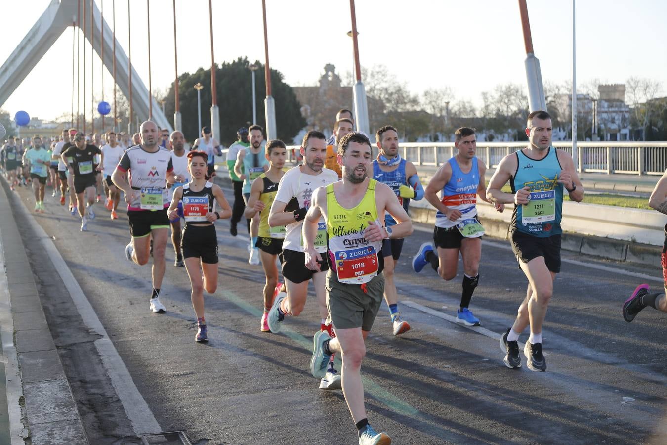 Corredores del maratón a su paso por el puente de la Barqueta