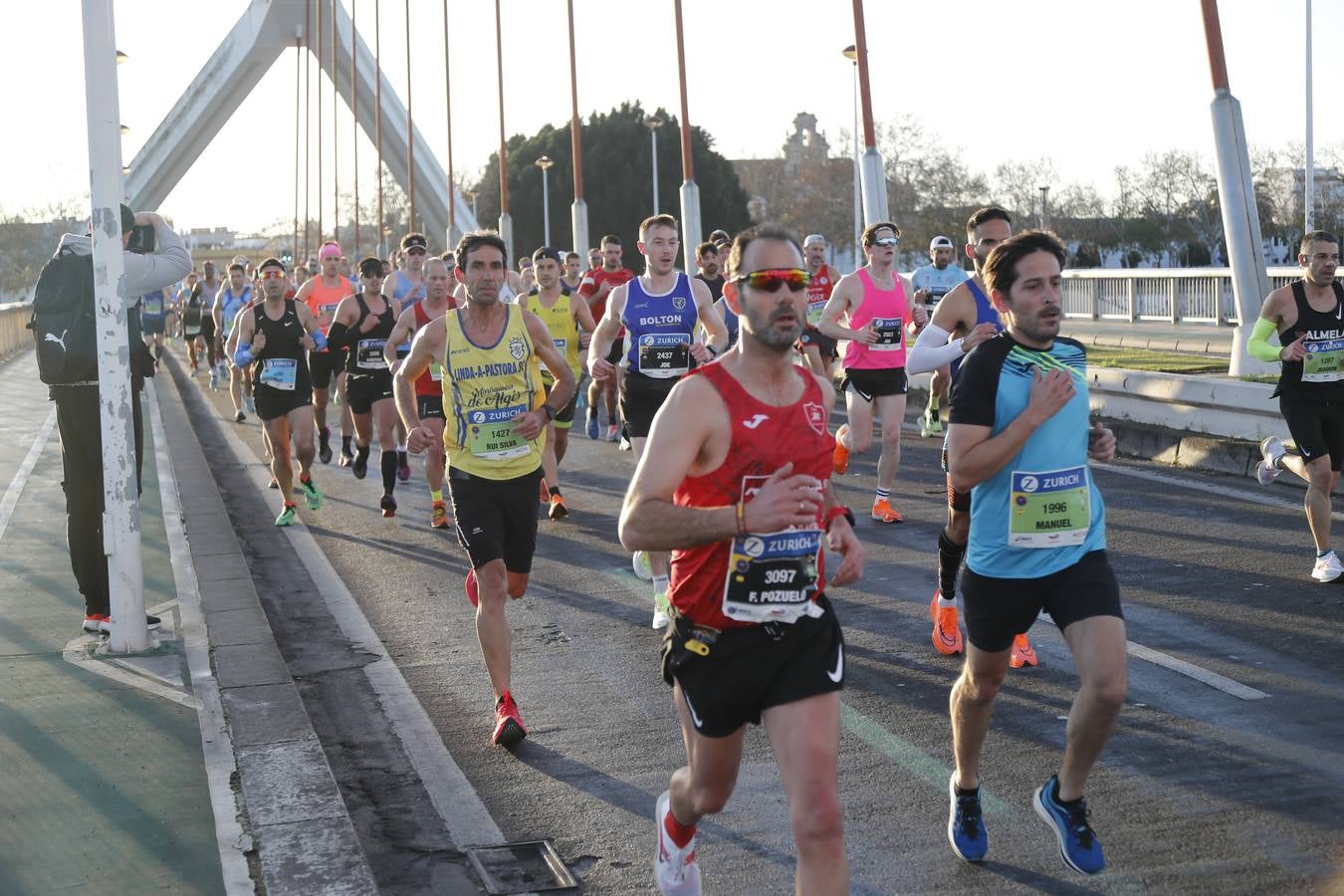 Corredores del maratón a su paso por el puente de la Barqueta
