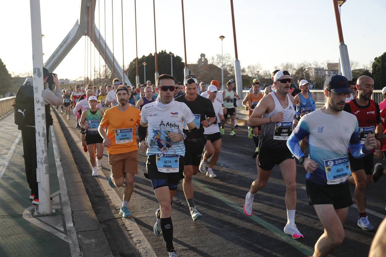Corredores del maratón a su paso por el puente de la Barqueta
