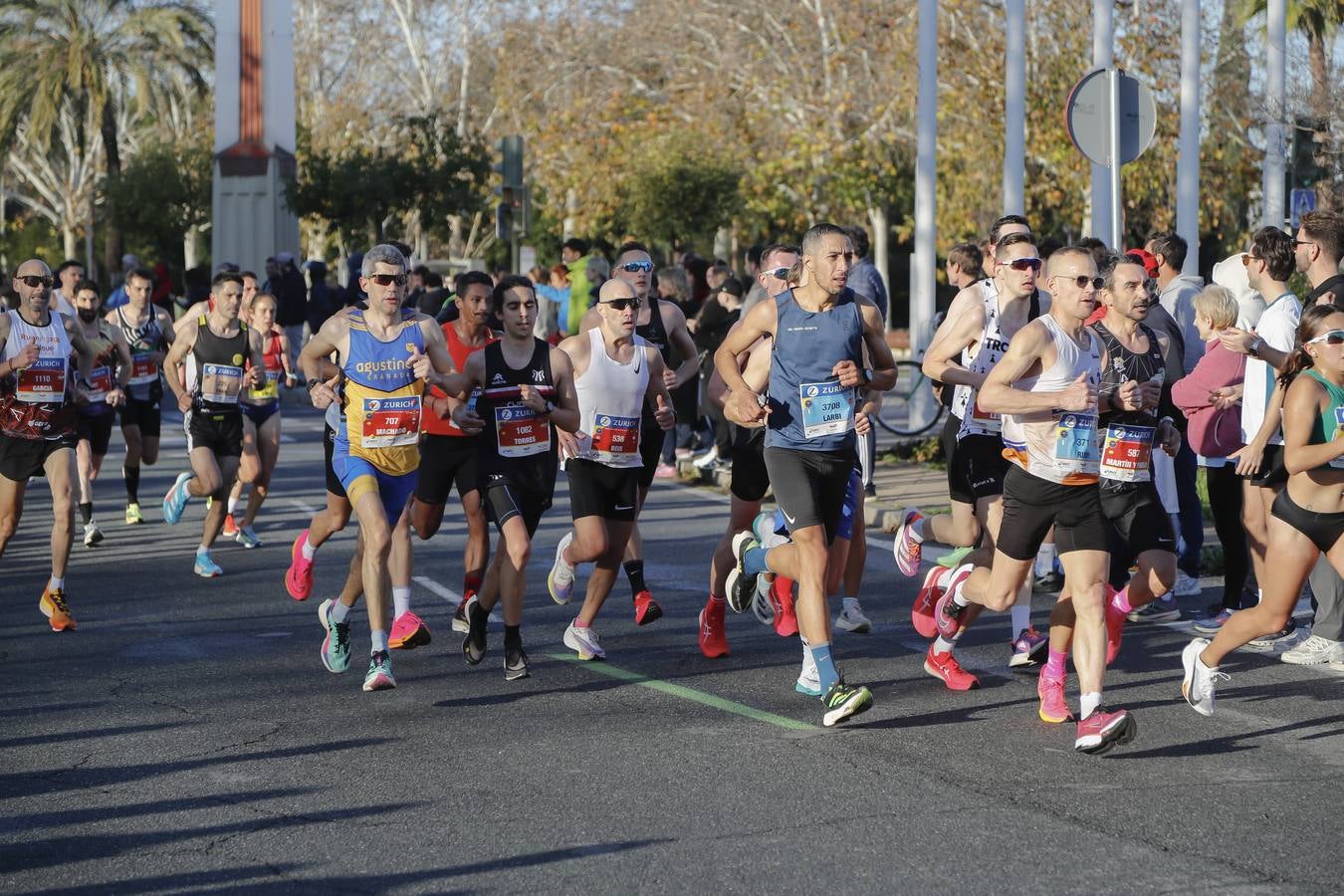 Corredores del maratón a su paso por el puente de la Barqueta