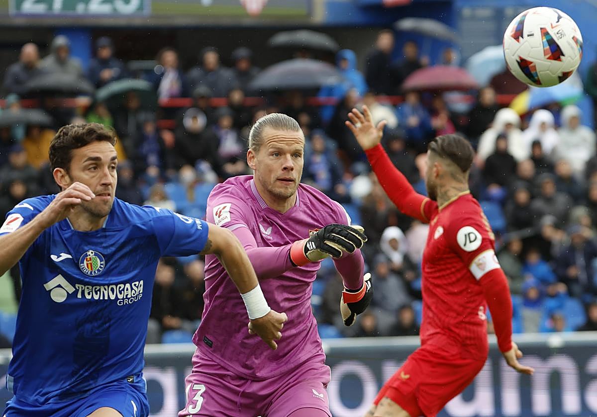 El delantero del Getafe Jaime Mata (i) disputa un balón ante el portero noruego Orjan Nyland del Sevilla, durante el partido entre el Getafe y el Sevilla FC, correspondiente a la jornada 30 de LaLiga, disputado este sábado en el Estadio Coliseum