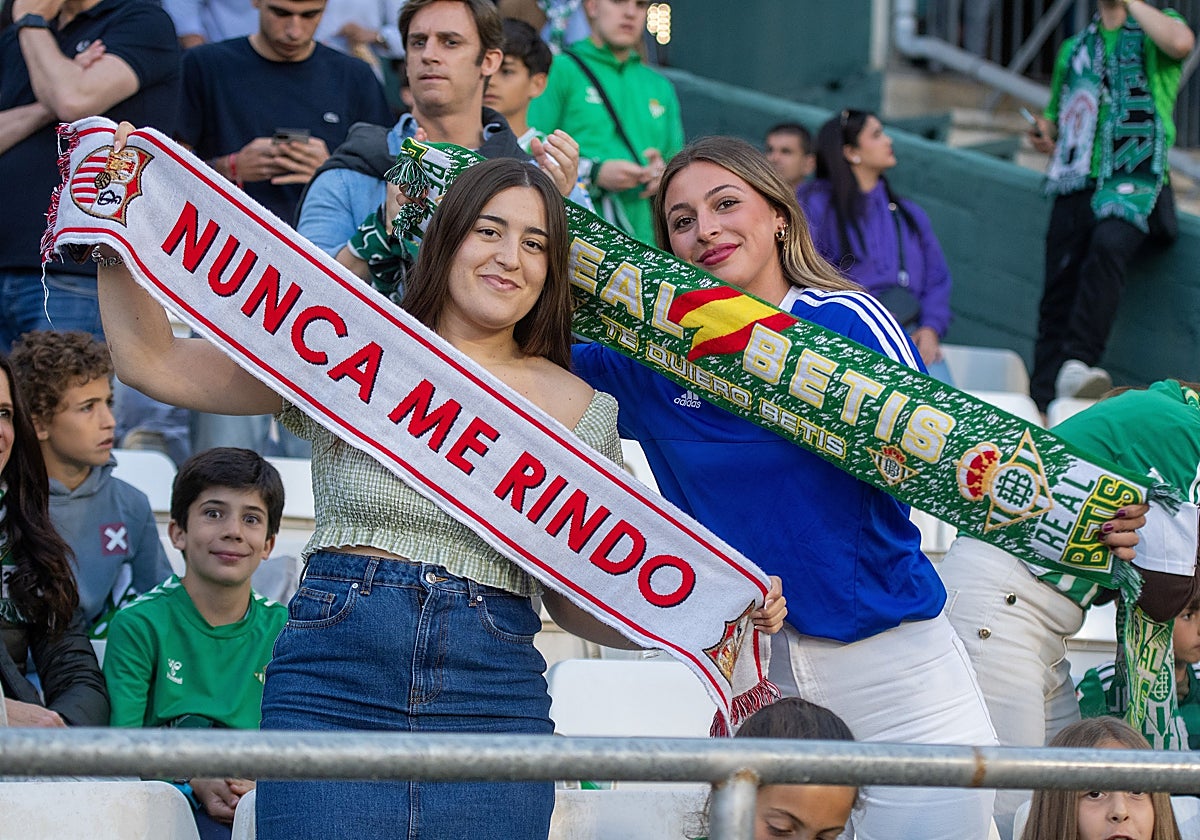 Aficionadas de Betis y Sevilla posan con sus bufandas en el Benito Villamarín durante El Gran Derbi