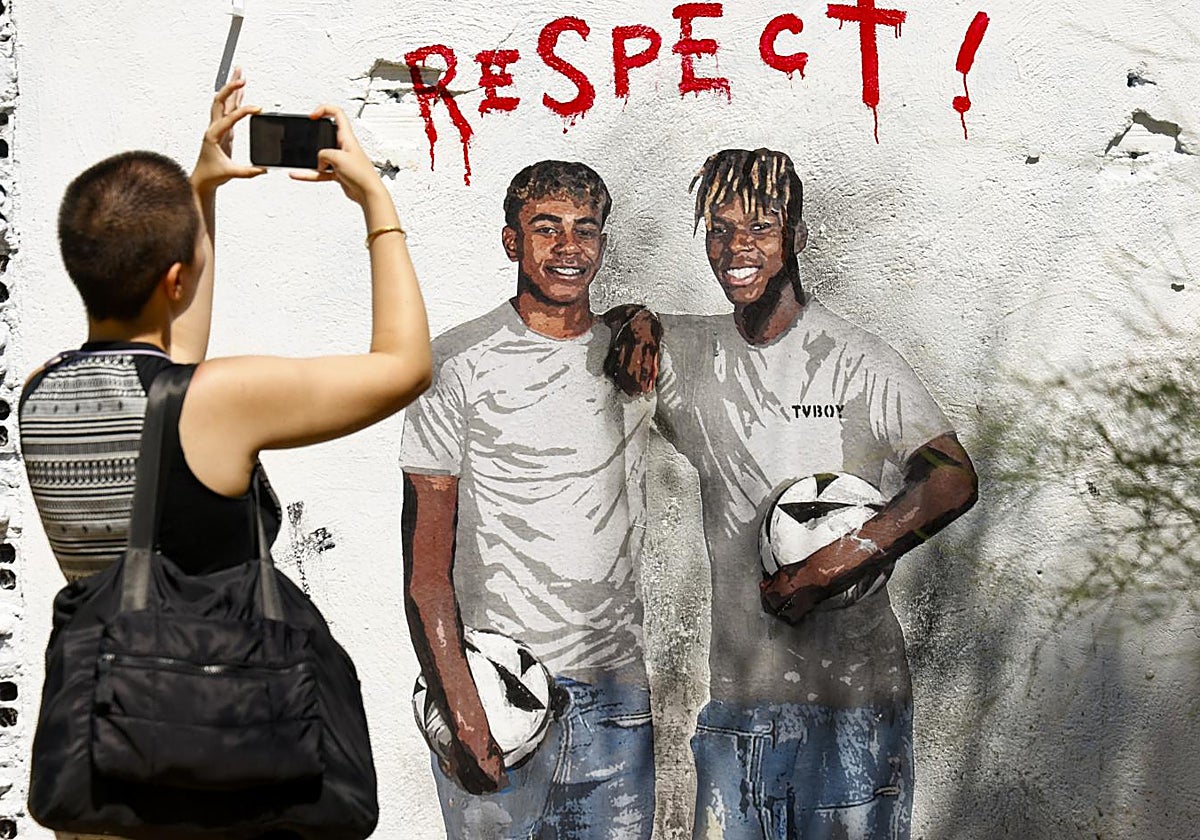 Una aficionada, ante un mural de Lamine y Nico en Barcelona