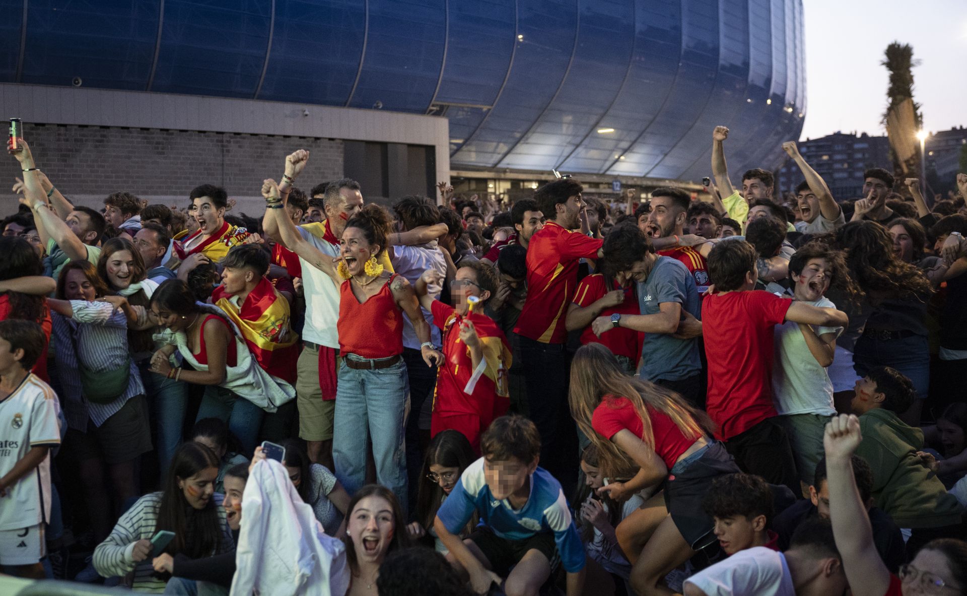 Junto al Reale Arena, los espectadores donostiarras se abrazan tras ver a Mikel Oyarzabal, uno de sus jugadores, marcar el último gol del torneo