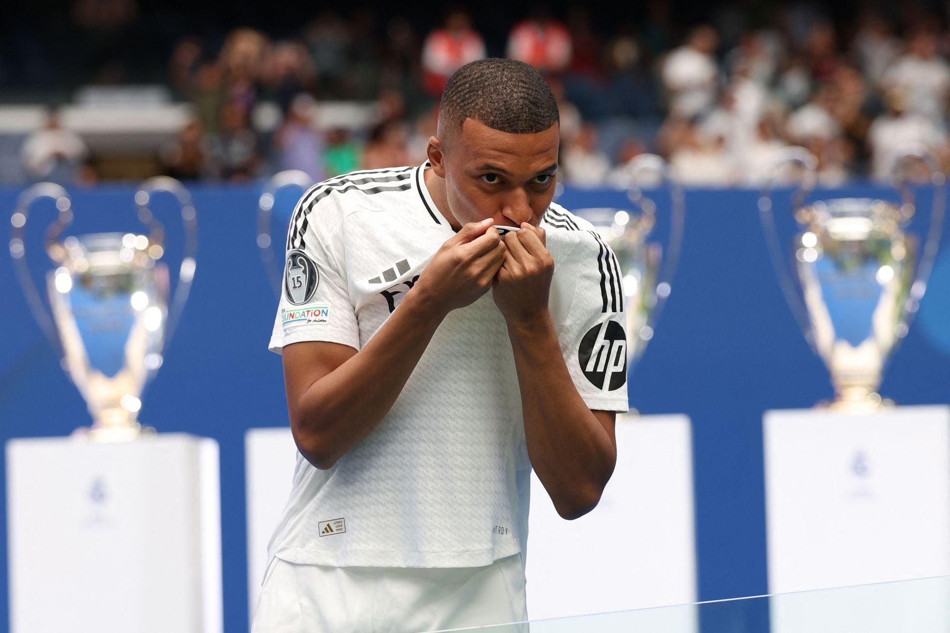 Han hecho falta varias peticiones para conseguir que Mbappé se bese su nuevo escudo en una imagen para la historia del madridismo