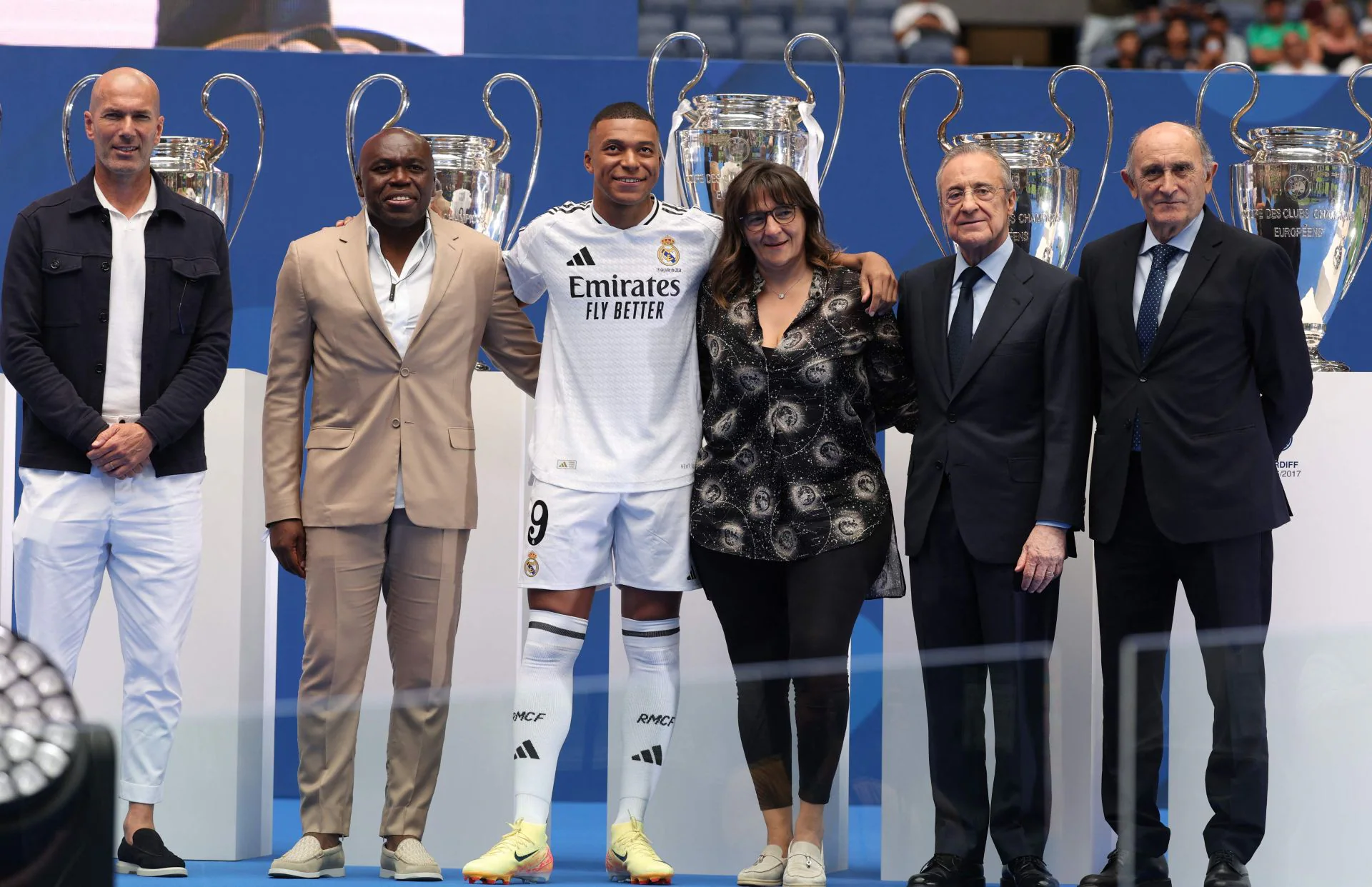 Antes de dirigirse a la rueda de prensa, el francés se ha hecho una foto con las 15 copas de Europa conseguidas por el Real Madrid en toda su historia de fondo, además de estar acompañado (de izdo a dcha) por Zidane, su padre, su madre, Florentino Pérez y 'Pirri'