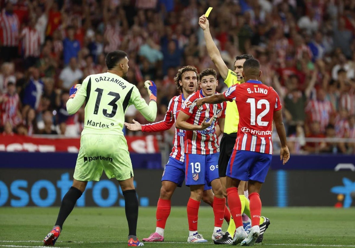 Martínez Munuera muestra la tarjeta amarilla al portero Gazzaniga tras tocar el balón fuera de su área