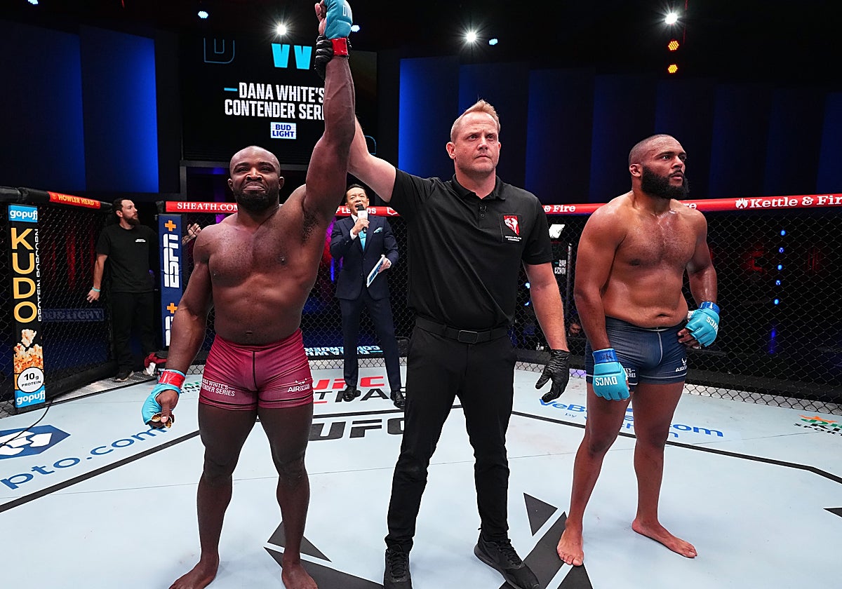 El árbitro levanta la mano de Torrez Finney como ganador del combate