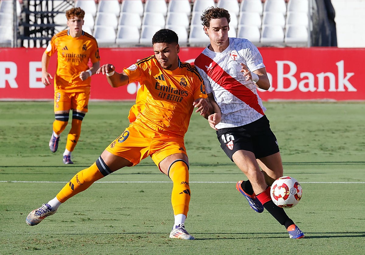 El jugador del Castilla Loren Zúñiga pugna con el sevillista Manu Bueno