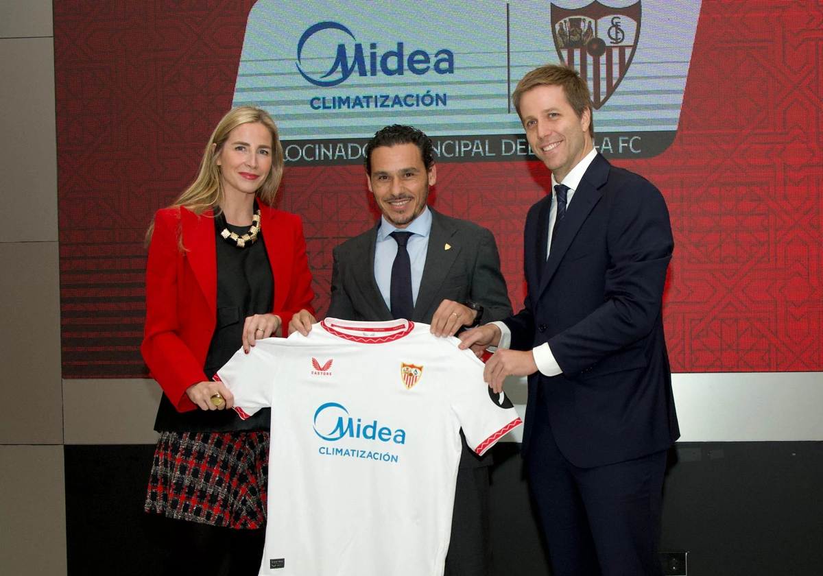 Del Nido Carrasco posa con la camiseta del Sevilla con el nuevo patrocinador principal Midea junto a Anna Rigol y Juan Rigol, CEOS de la compañía