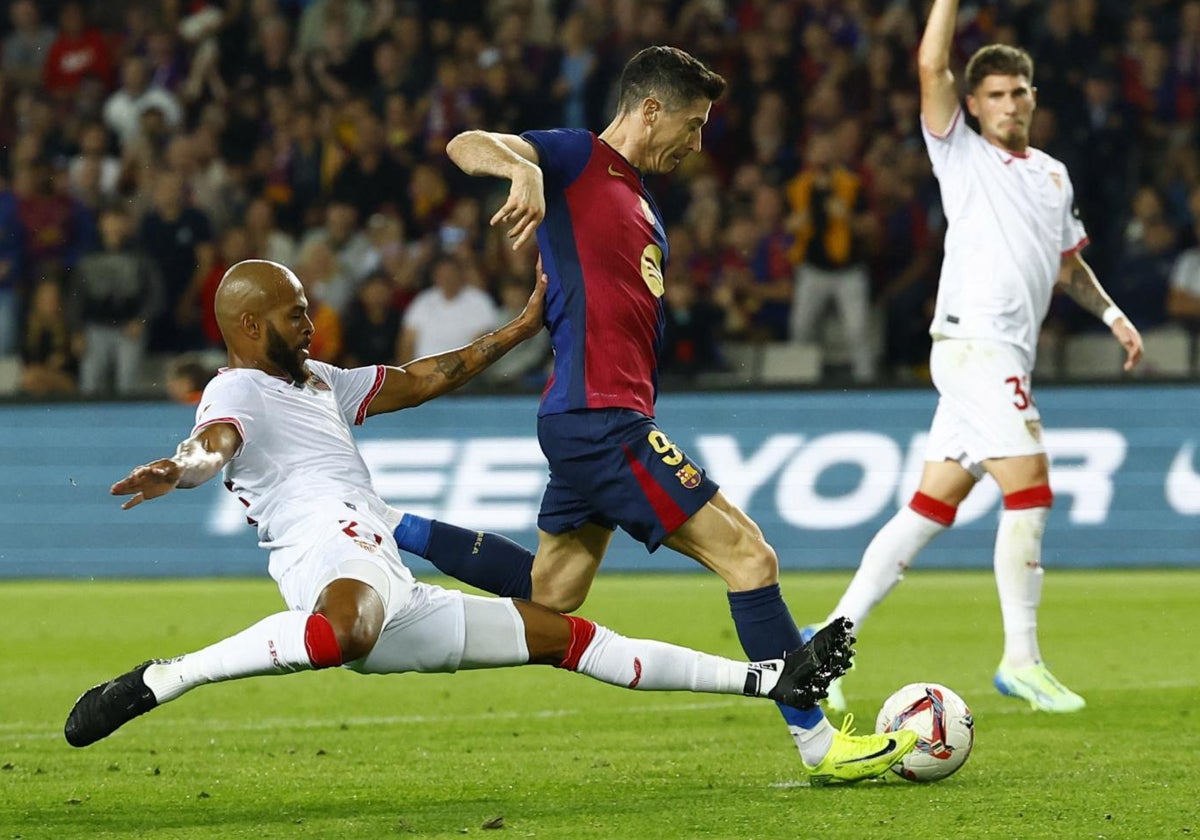 Marcao intenta detener a Lewandowski en el duelo Barcelona - Sevilla de Montjuic