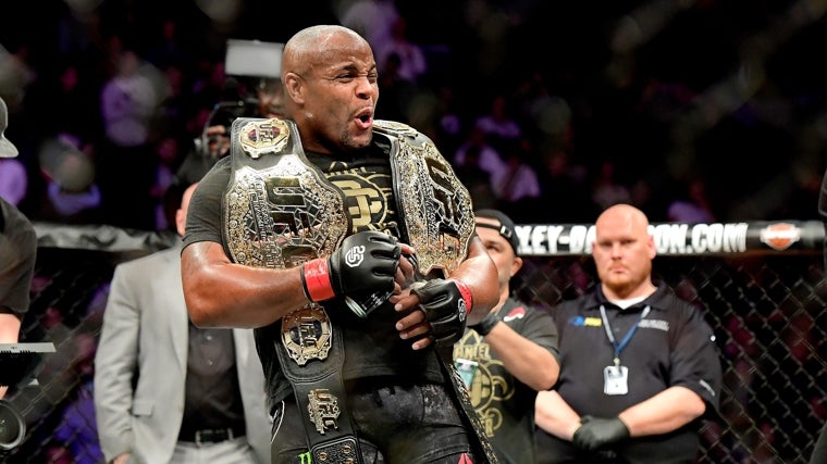 Daniel Cormier con sus dos cinturones de campeón
