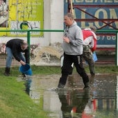 Personal y aficionados del Atlético Astorga achicando agua de La Eragudina