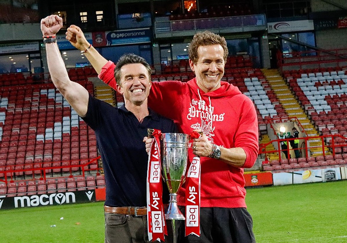 Rob McElhenney y Ryan Reynolds, en el campo del Wrexham celebrando el ascenso