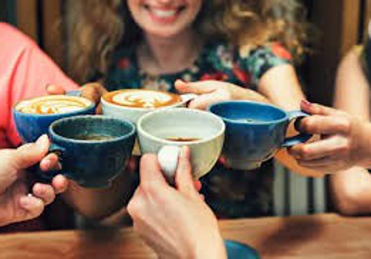 Un grupo de amigos toman un café en una cafetería de Suiza