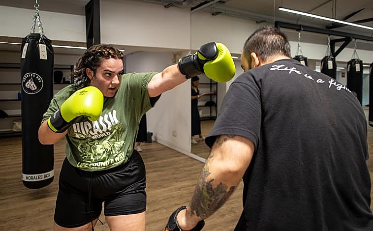 Imagen principal - En la primera imagen, Esperanza practica golpes durante un entrenamiento; Patricia, en la segunda foto, posa a los pies del ring e Idalisa y su hija Patricia siguen la clase.