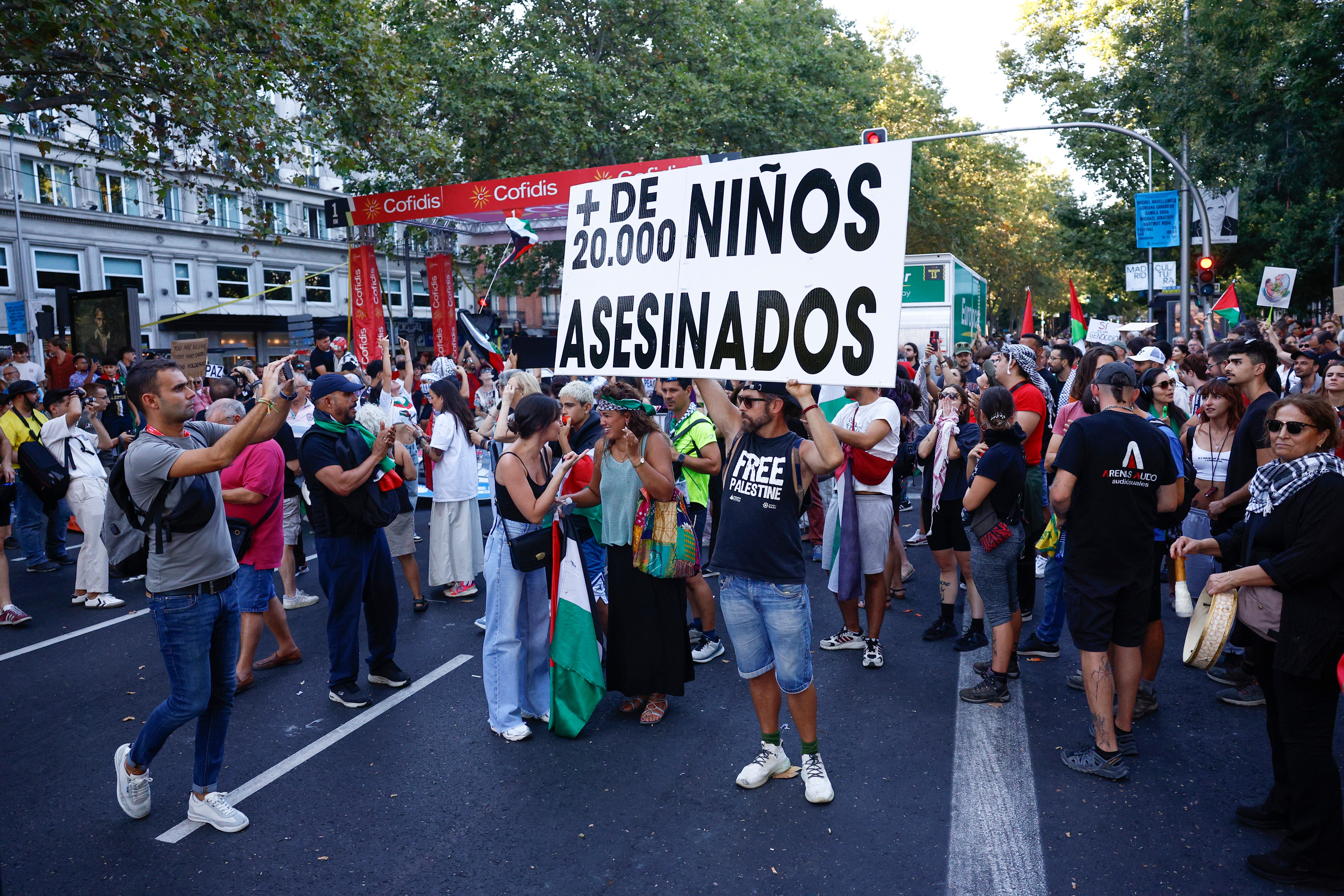 Pancartas contra la guerra en Gaza en la protesta de este domingo en Madrid, que ha obligado a parar la etapa final de La Vuelta.