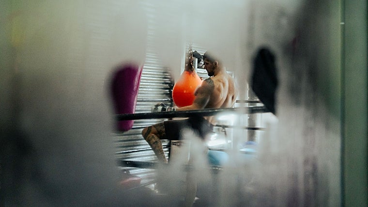 Joel Álvarez golpe a un saco, mientras los cristales del gimnasio 'sudan'