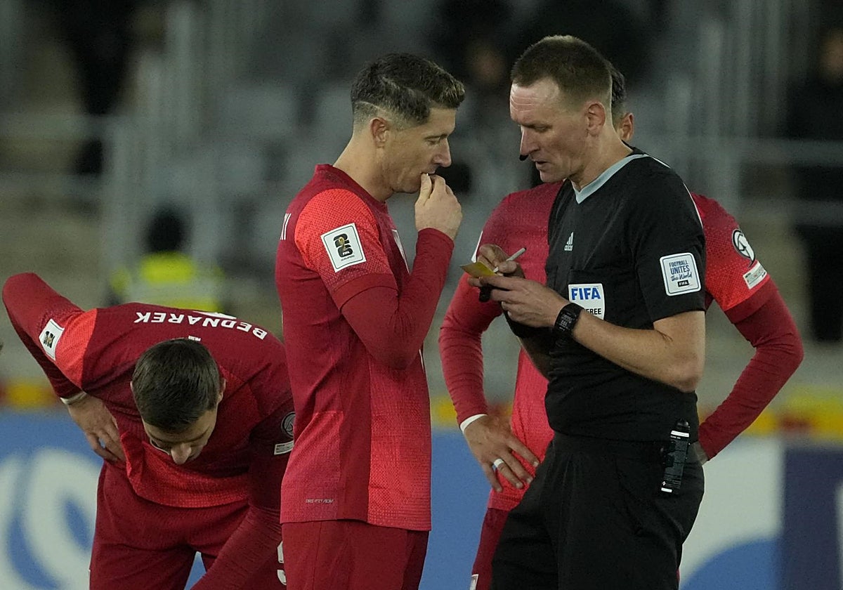 Lewandowski habla con el árbitro durante un partido de Polonia