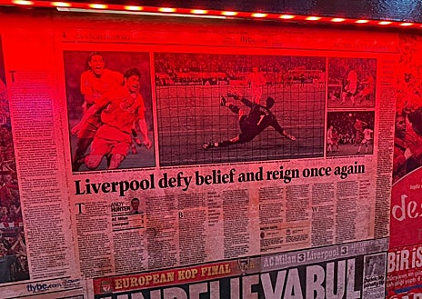 Imagen secundaria 1 - Decoración y recortes en el bar Reds, uno de los principales de los hinchas del Liverpool. A la derecha, las botas de Xabi firmadas