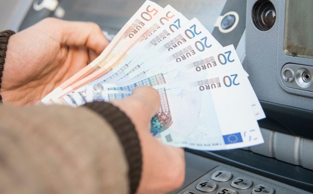 Un usuario retira dinero en efectivo de la sucursal bancaria