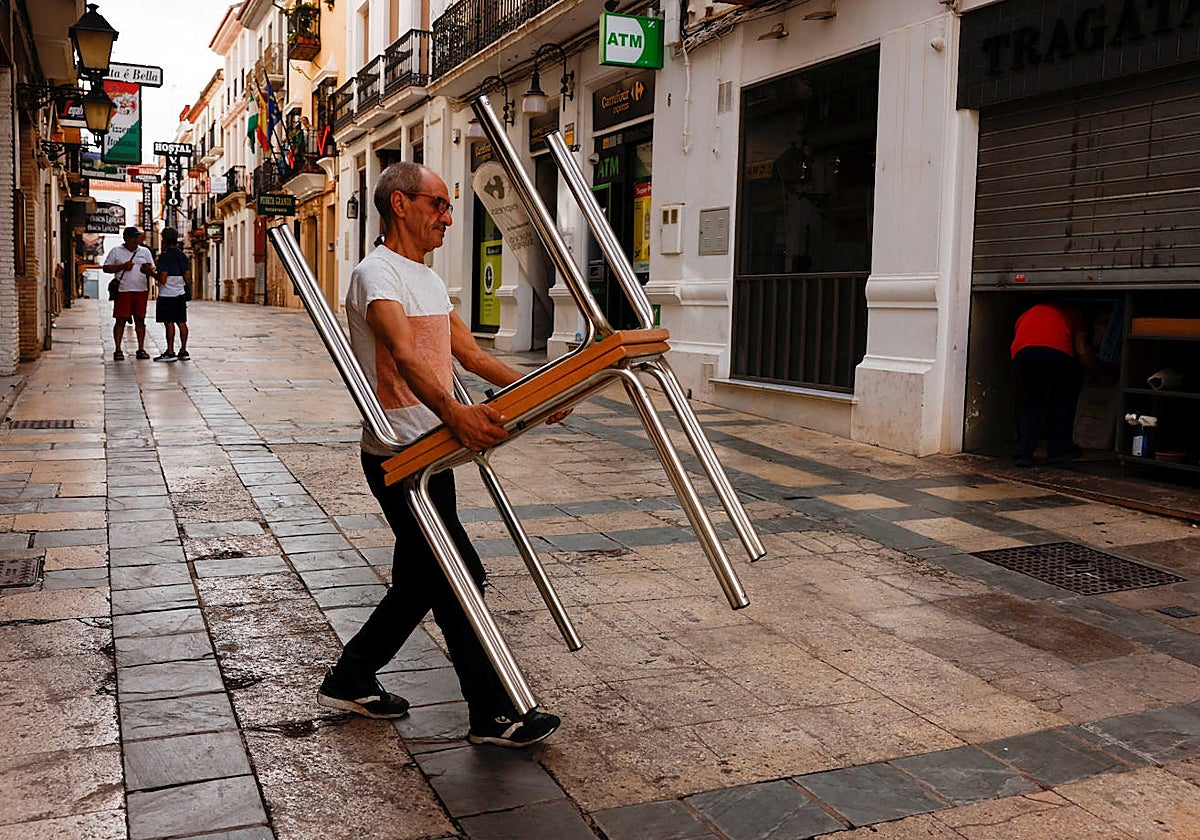 Un camarero cargando mesas de su restaurante