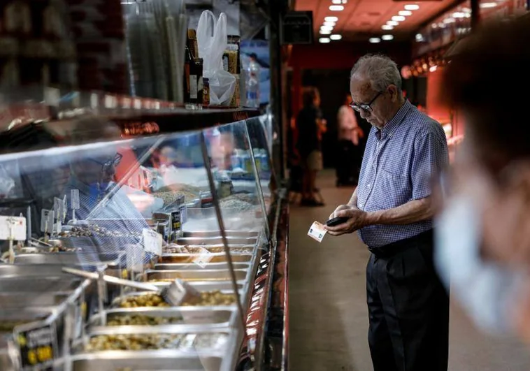 A man prepares euros to pay for a purchase at a market in Madrid