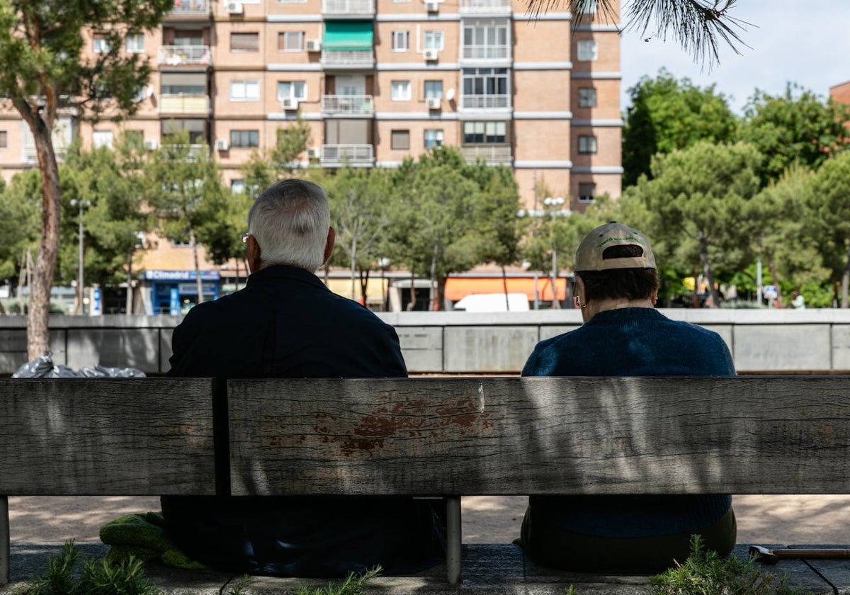 Dos jubilados sentados en un banco en Madrid