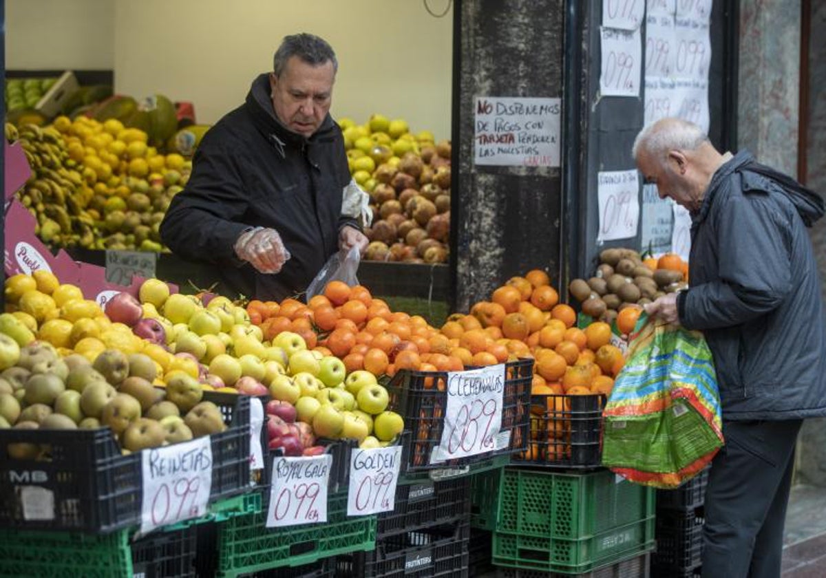 Consumidores hacen la compra en un mercado callejero