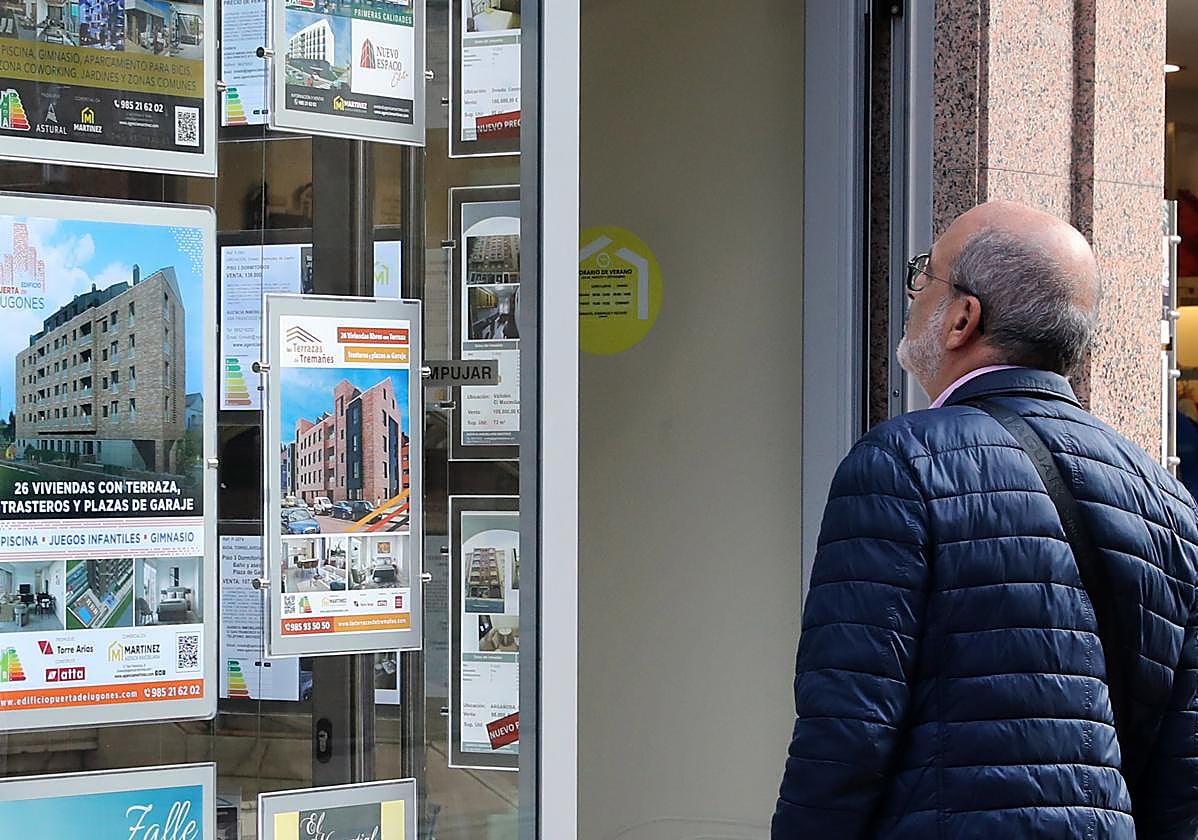 Un hombre mira viviendas en una inmobiliaria.