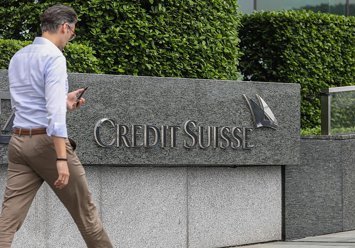 Un hombre camina frente a la sede de Credit Suisse