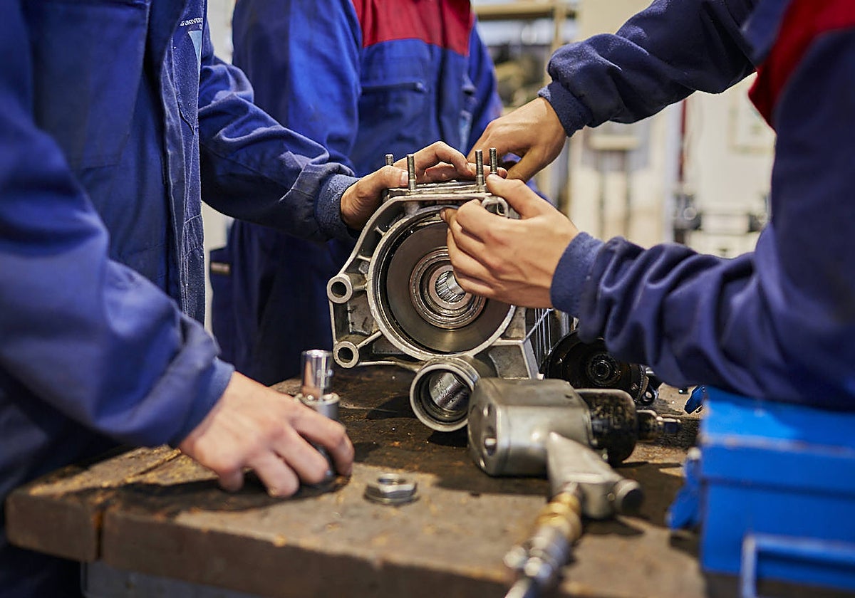 Varias personas aprenden mecánica en el IES Universidad Laboral