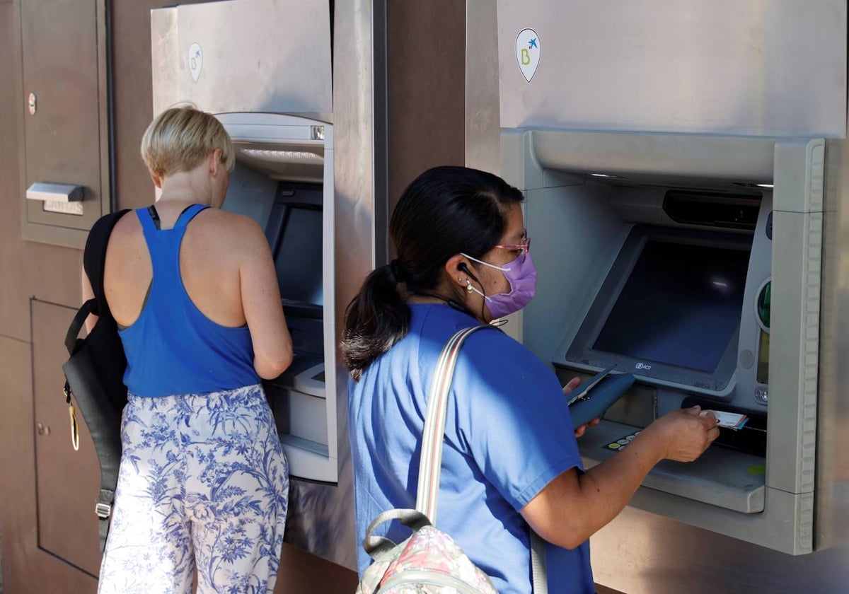 Dos mujeres sacando dinero de un cajero en Madrid
