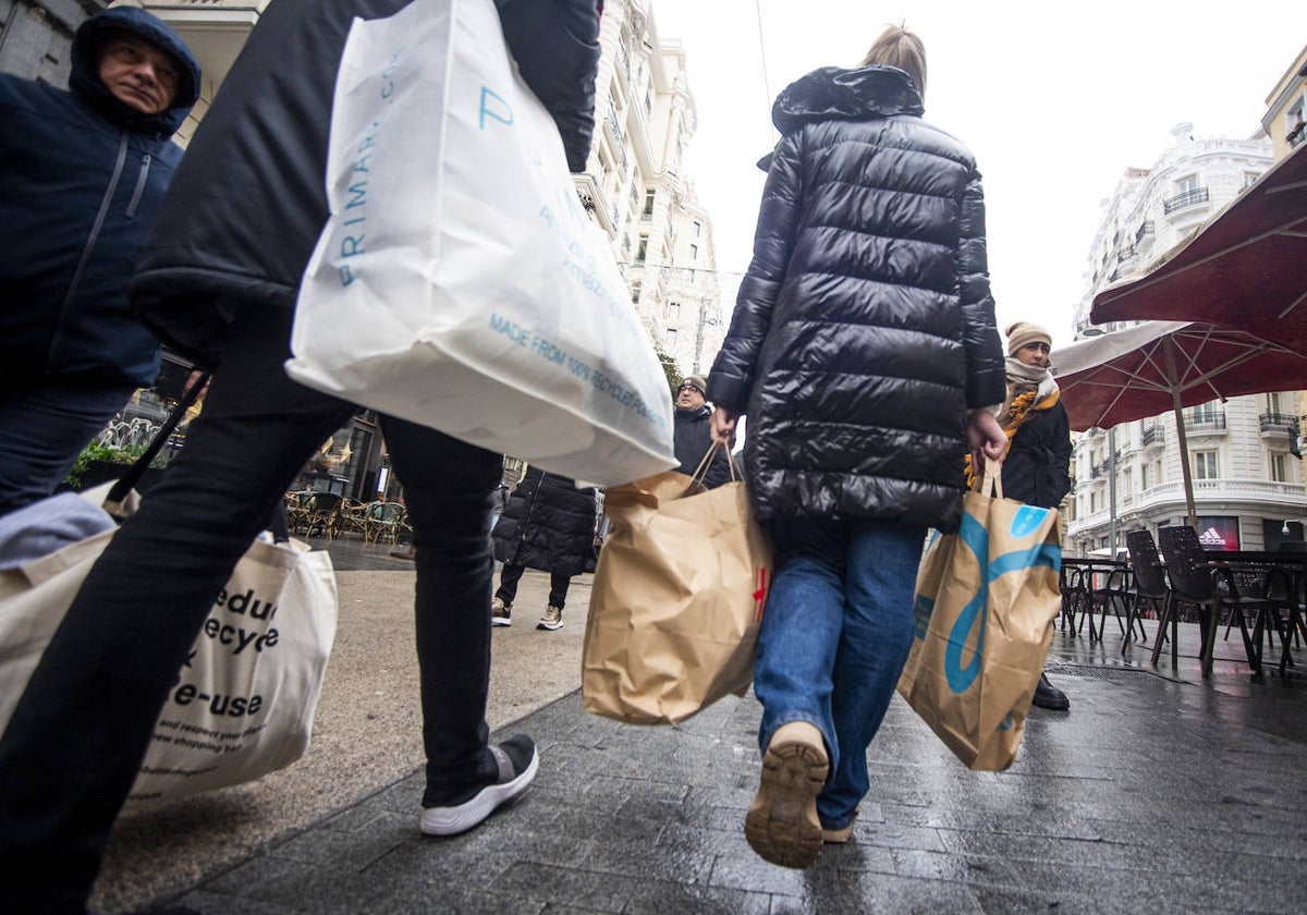 Viandantes con bolsas de varios comercios por el centro de Madrid