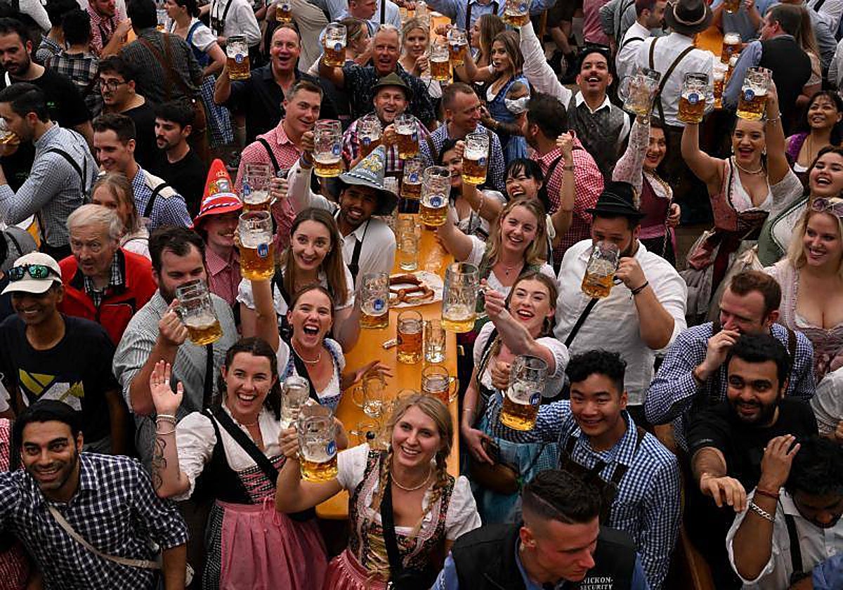 Varios asistentes alzan sus jarras en la celebración de la Oktoberfest