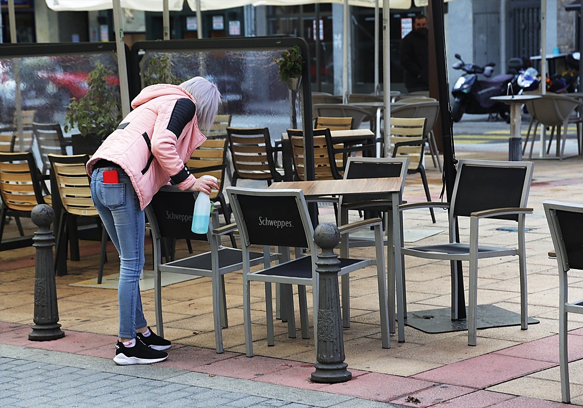 Una camarera desinfecta una mesa en León (Castilla y León)