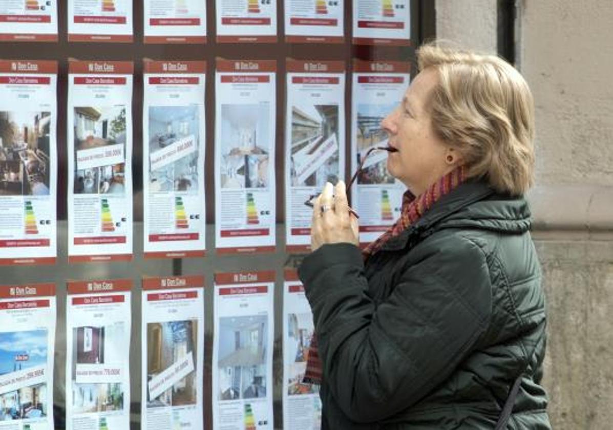 Imagen de archivo de una mujer mirando las propiedades en venta de una inmobiliaria