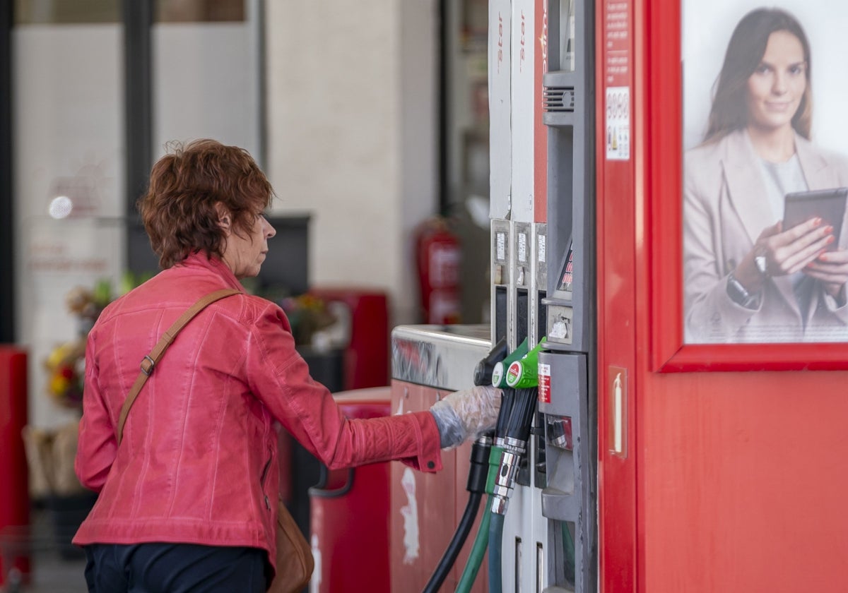 Una mujer reposta en una gasolinera