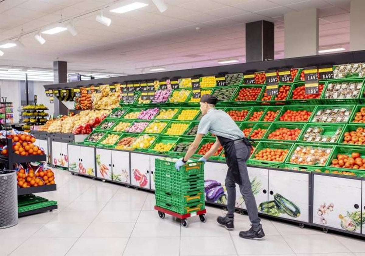 Un trabajador repone productos en un supermercado