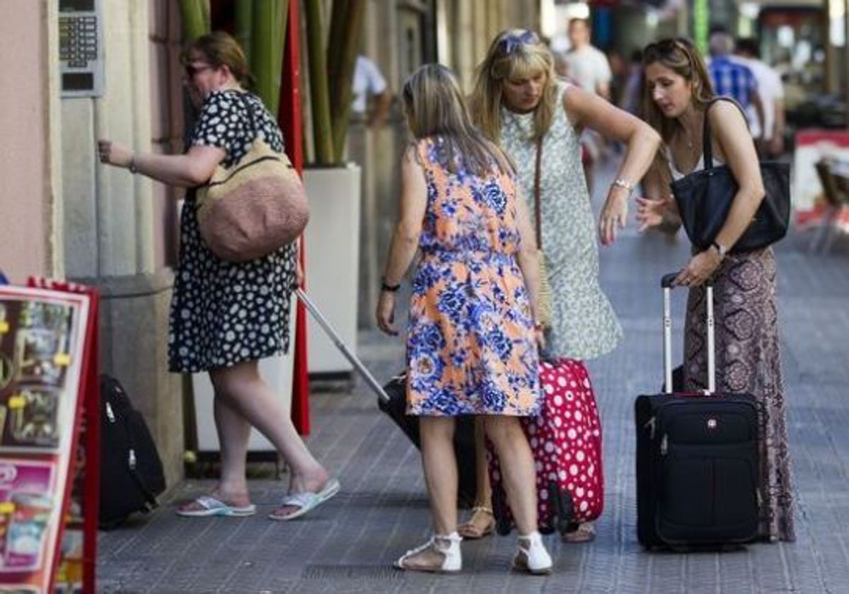 Un grupo de turistas accede a un edificio en el centro de una ciudad