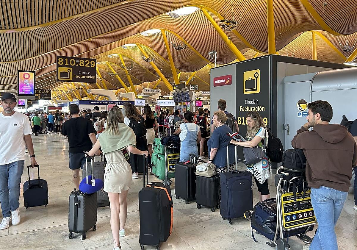 Varias personas hacen cola en la zona de facturación de la T-4 del Aeropuerto de Madrid tras la incidencia global de Microsoft