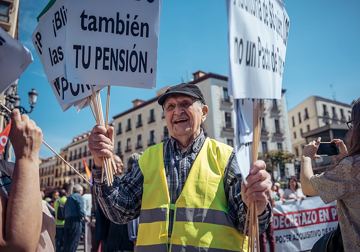 Un manifestante con pancartas durante la manifestación contra las reformas de pensiones llevadas a cabo por el Gobierno en la presente legislatura, a 15 de abril de 2023, en Madrid