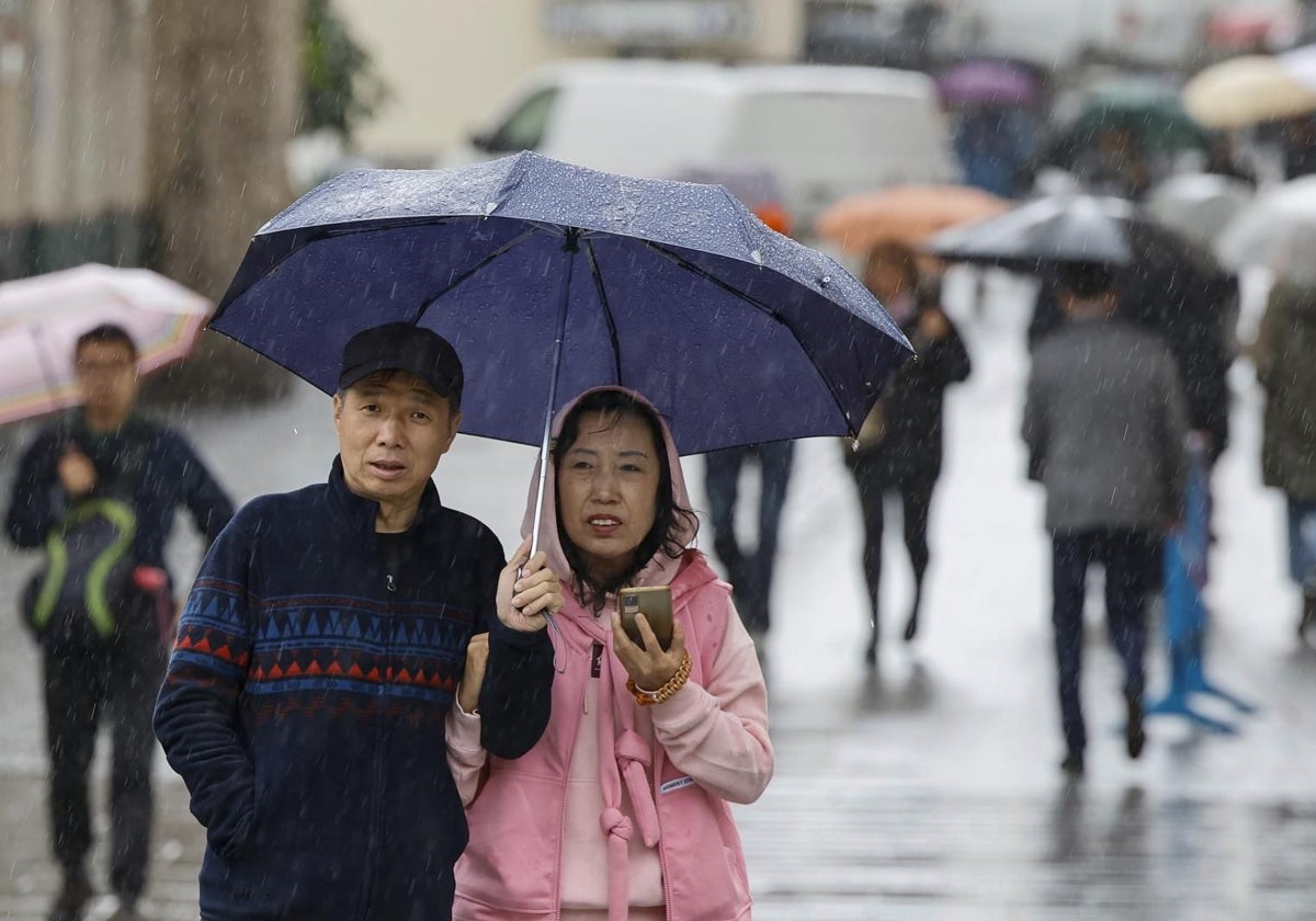 Turistas recorren las calles de Sevilla bajo la lluvia