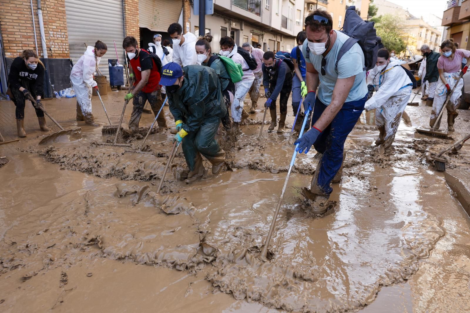Voluntarios limpian una calle de Paiporta