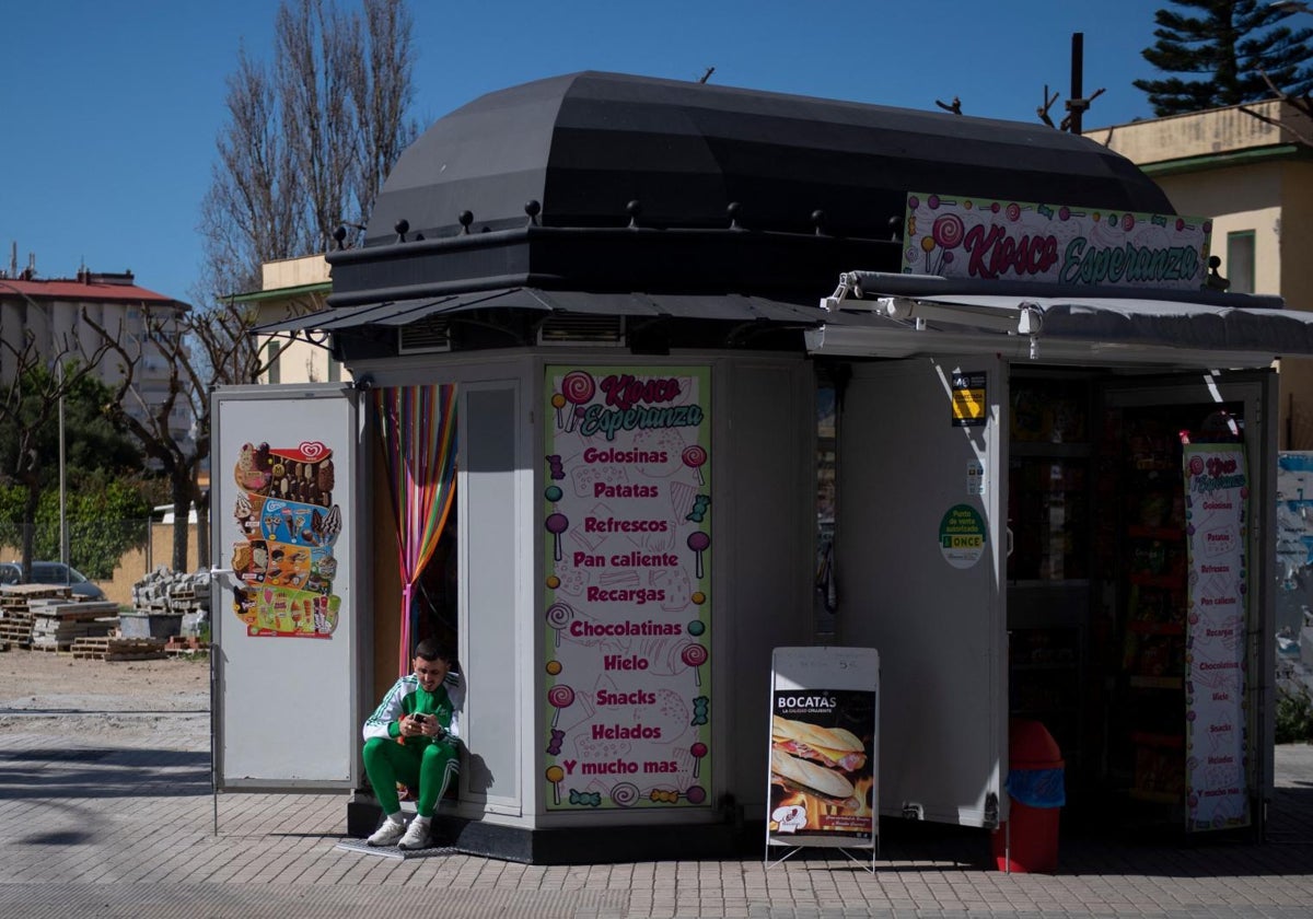 Un joven mira su móvil en un kiosko de La Línea de la Concepción