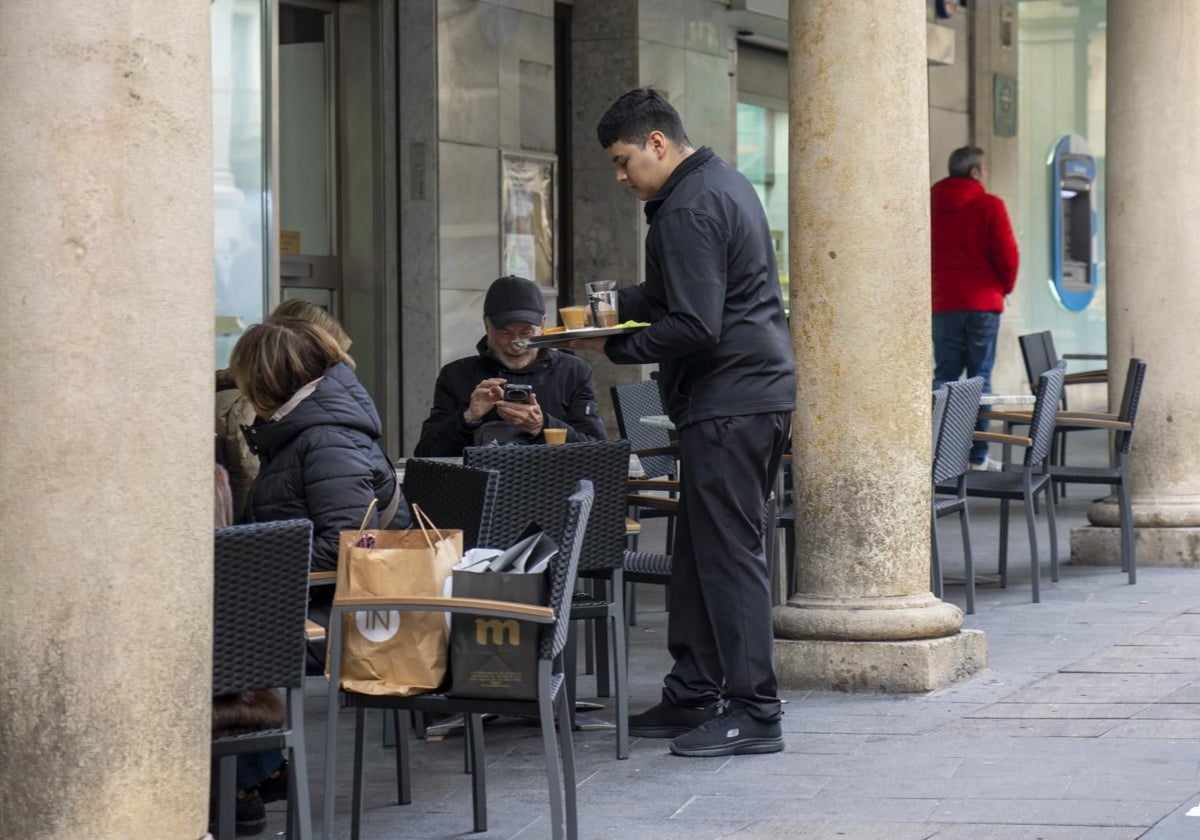 Un camarero atiende a un cliente en una terraza de Teruel